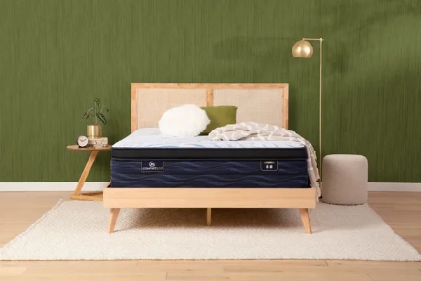 The Serta iComfort ECO collection hybrid mattress against a green wall 