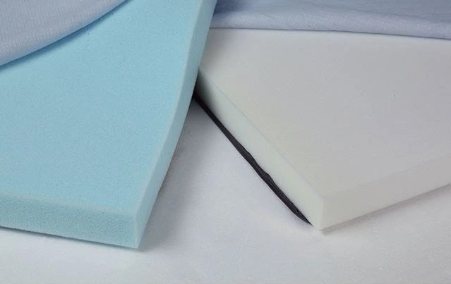 Close up of a blue and a white mattress topper laid out on a mattress