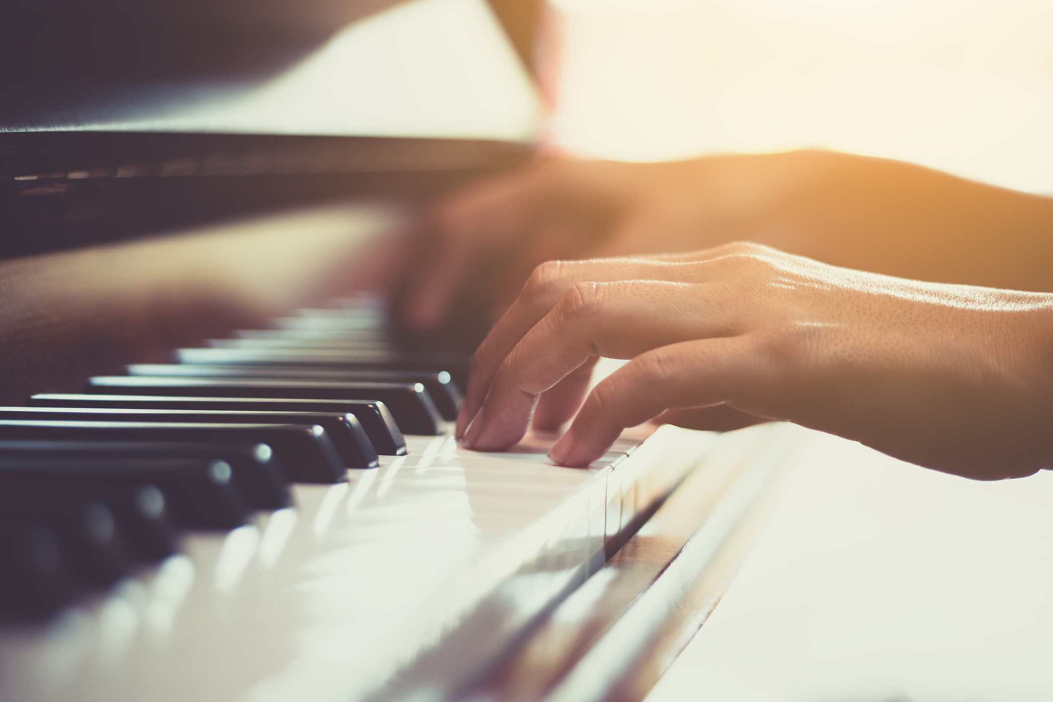 close up of persons hands playing the piano