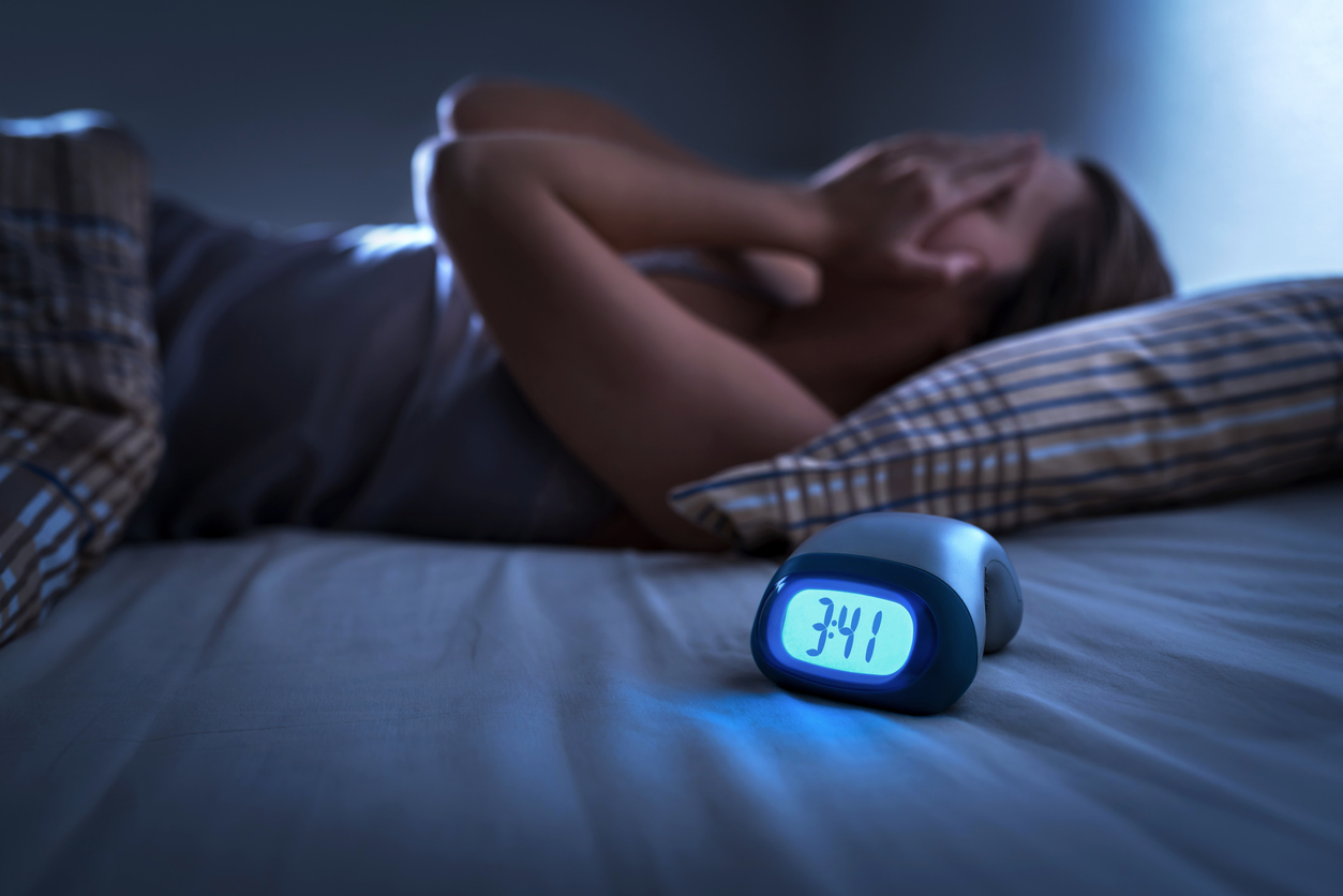 Woman suffering from not being able to sleep on her old mattress 
