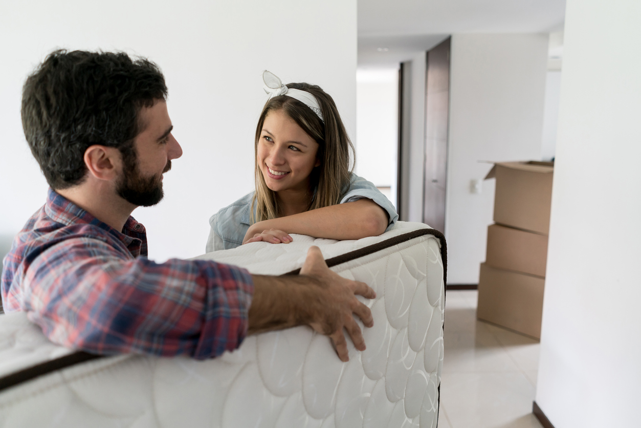 young woman and young man move their new mattress into their new place
