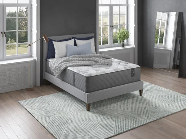 Mattress, pillows, and blanket in a gray bedroom