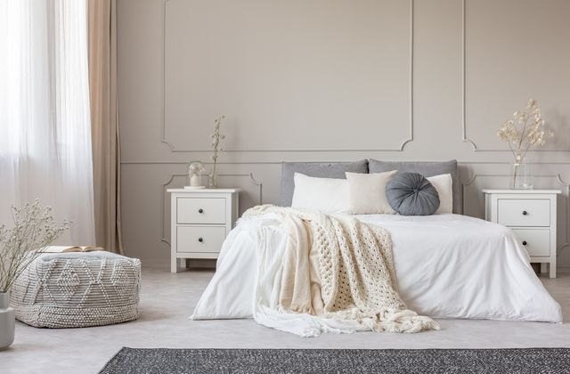 front view of a modern scandi style large white bedroom with two white nightstands