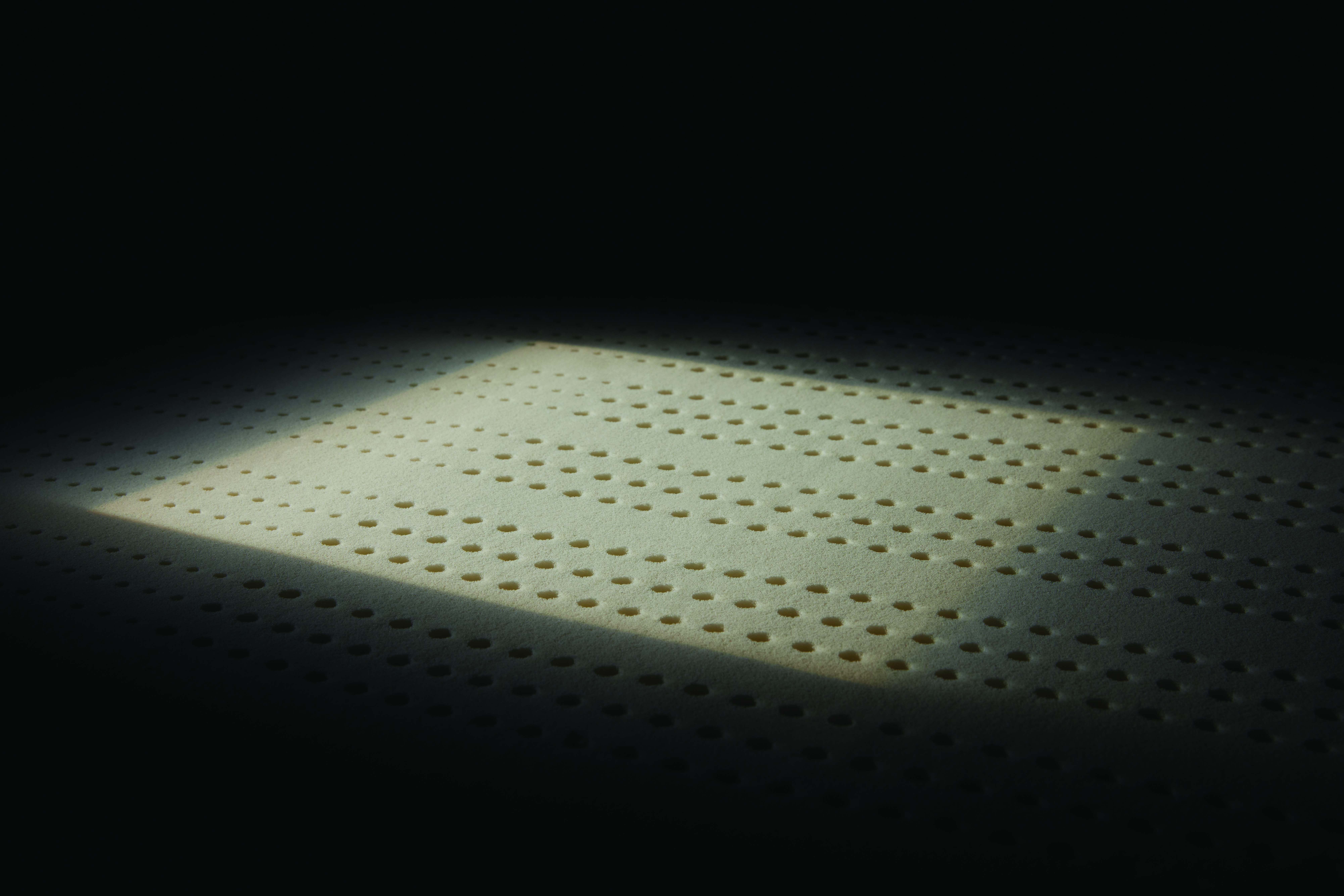 A latex mattress on a black background 