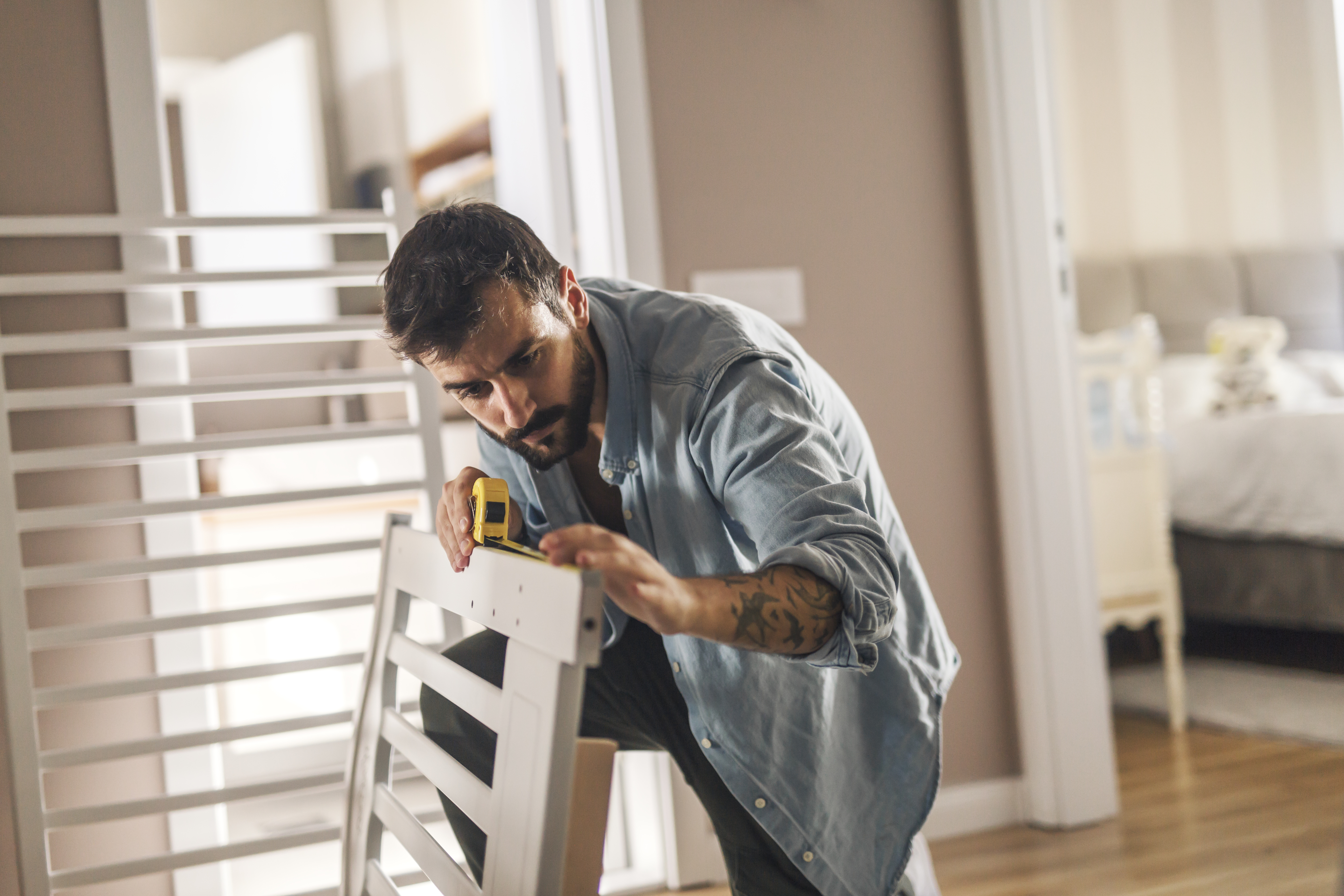 A man measuring a bed frame 