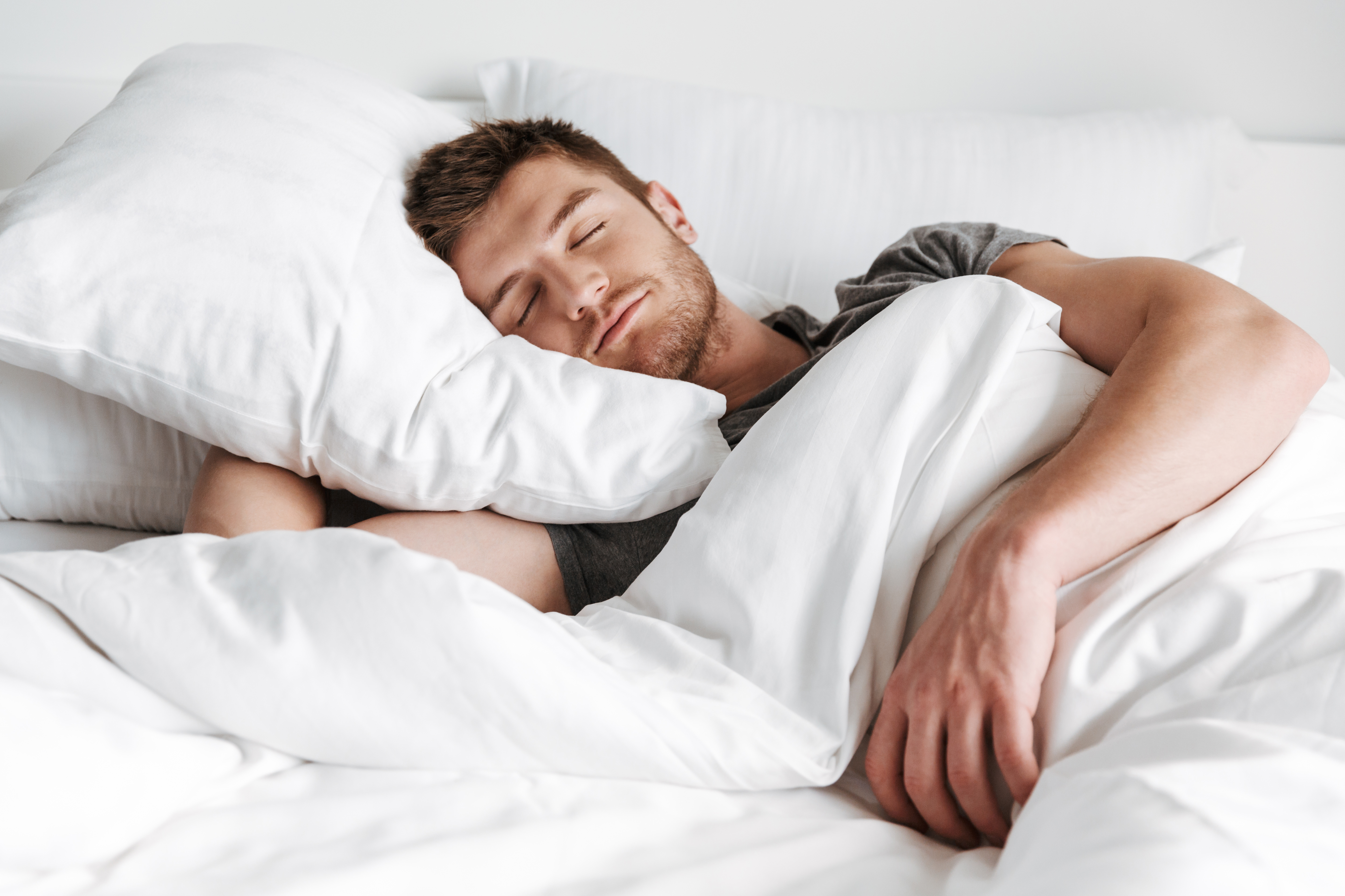 A young man sleeping in bed 