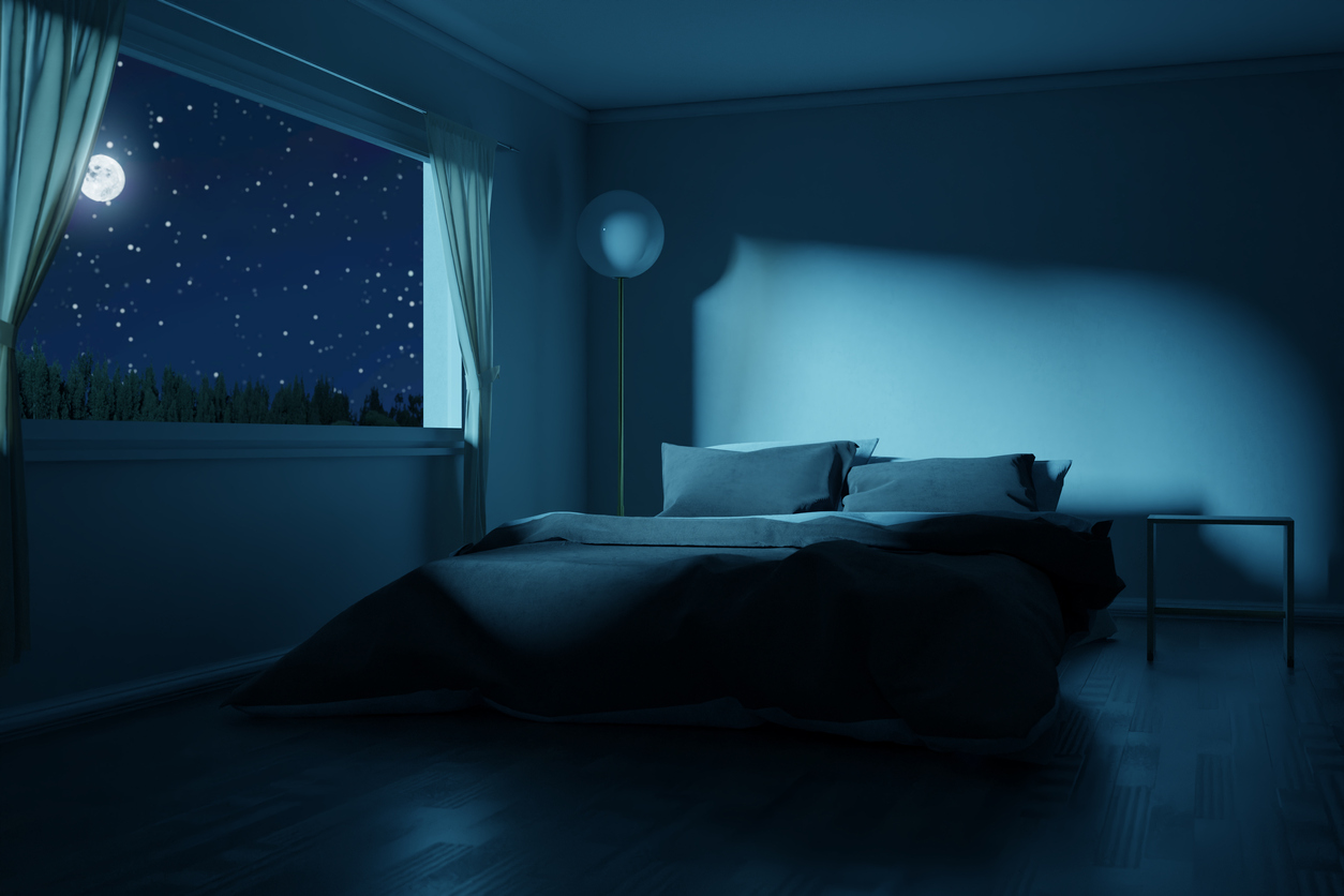 empty bed next to open with landscape of stars and moon