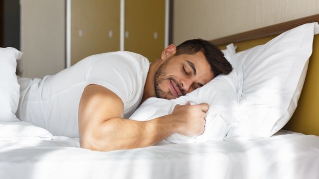 side view of a man sleeping on his stomach 
