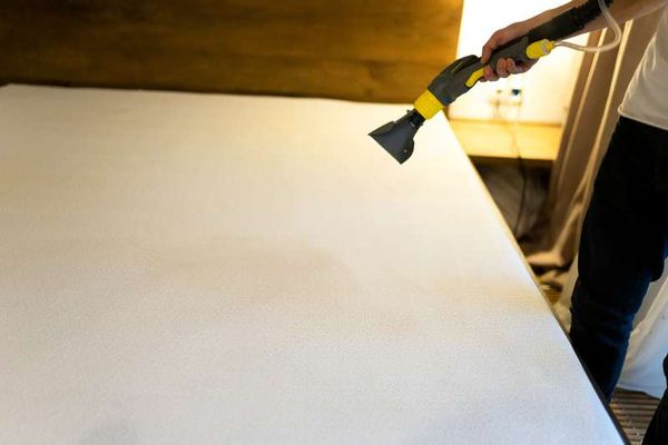 Someone uses a vacuum attachment to clean their mattress