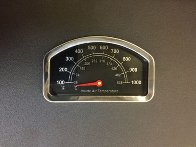 A close-up of a grill temperature gauge
