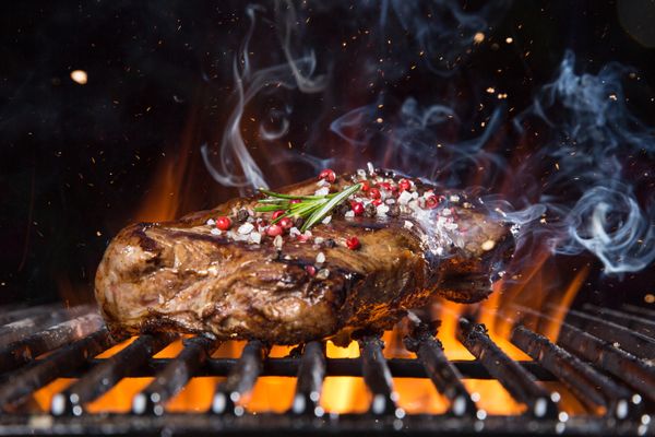 A close-up of a steak grilling