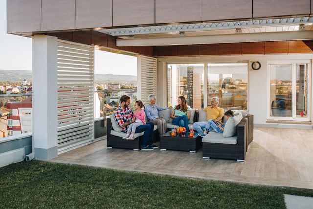 Front view of a large family sitting on an outdoor sectional with a desert city in the background