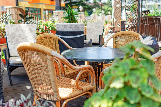 Close view of an outdoor patio furniture store with various pieces outside on display in the sunlight