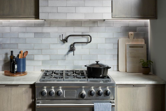 Front view of a modern kitchen with a range and pot filler faucet