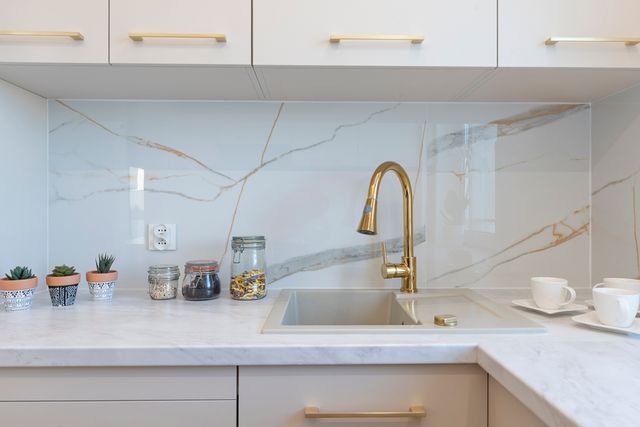 Front view of a small wet bar space with white counters and cabinetry.