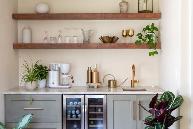 Front view of a modern home wet bar with gold hardware and accents
