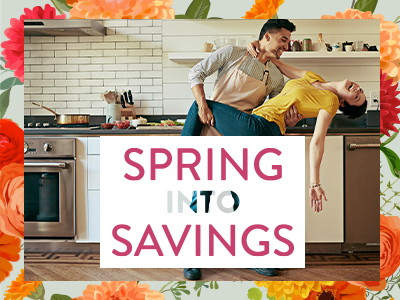 couple dances in their kitchen as they celebrate Spring into Savings appliance sale