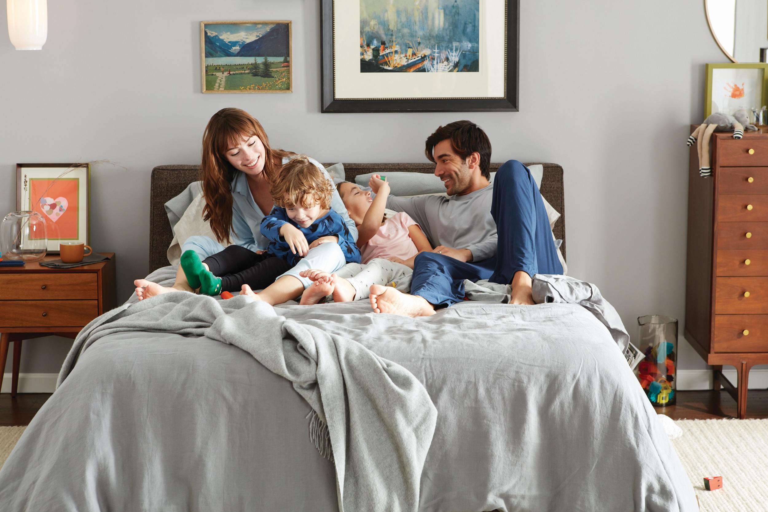 family lounges on Beautyrest mattress on a made bed