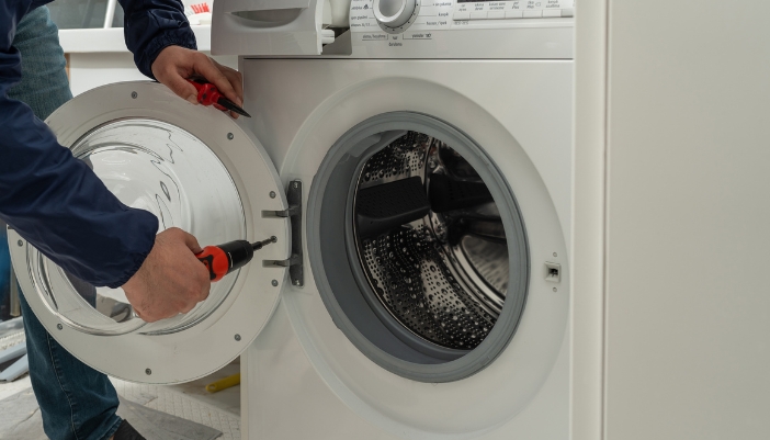 Closeup of someone refitting the washer door