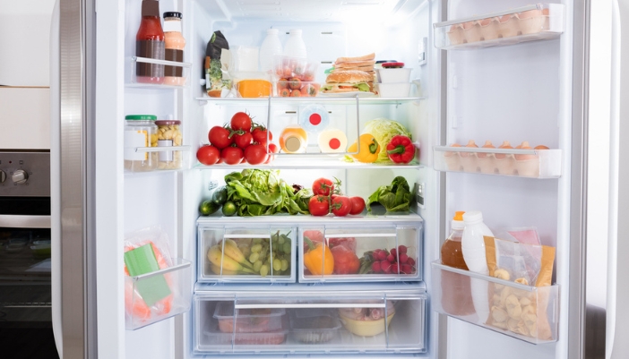 A well-stocked white fridge with open doors.