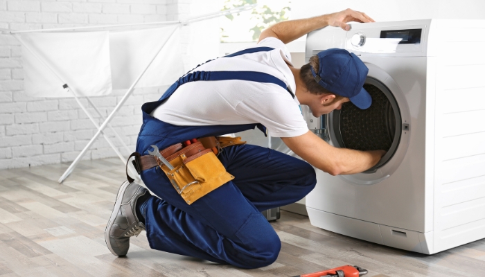 Service repairman fixing washer