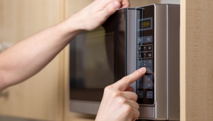 Closeup of someone pulling out the microwave plate