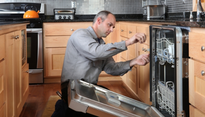 Service repair person taking out the dishwasher