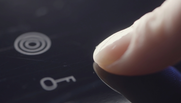 Closeup of hand trying to turn electric cooktop on