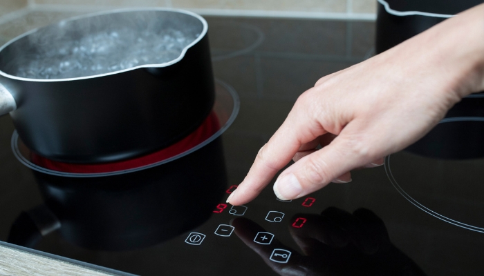 Closeup of someone adjusting the temperature on a boiling pot
