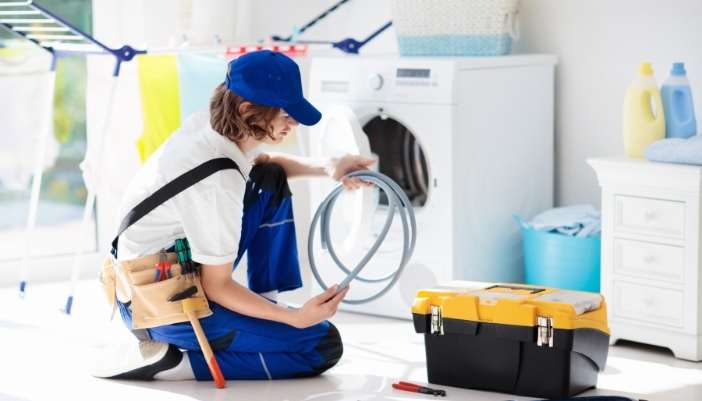 A professional service tech inspect a new hose for the laundry area