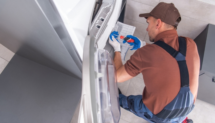 Closeup of service repairman fixing a dryer