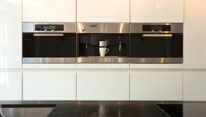 Closeup of a modern kitchen with two ovens and a built-in coffee machine