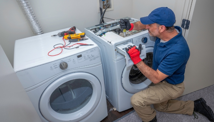 An appliance tech troubleshooting a washer