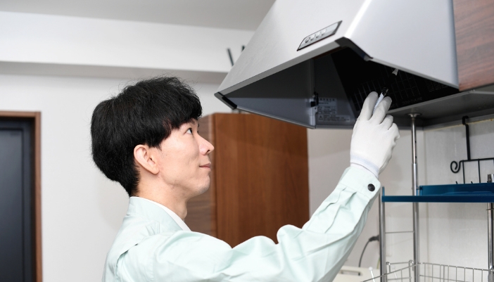 An appliance tech inspecting a range hood