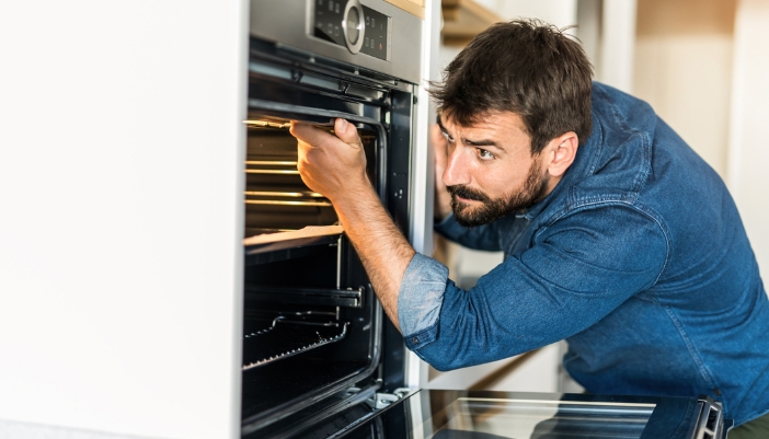 Closeup of a man removing obstructions from the door gasket so it’ll lock
