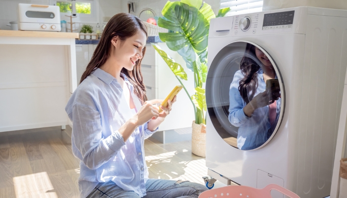 Happy woman who finished diagnosing the small issue on her washer