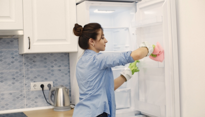 Woman cleaning the inside of her fridge