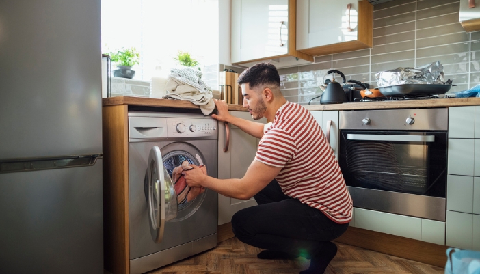 Man rearranging clothes to minimize vibration