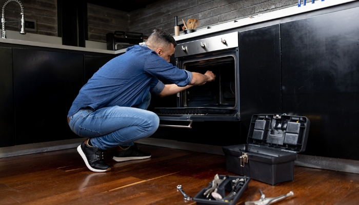 Appliance service tech fixing wall oven