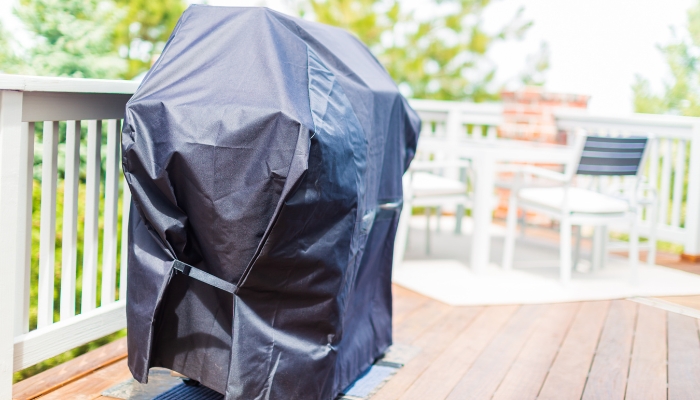 A covered grill on the deck