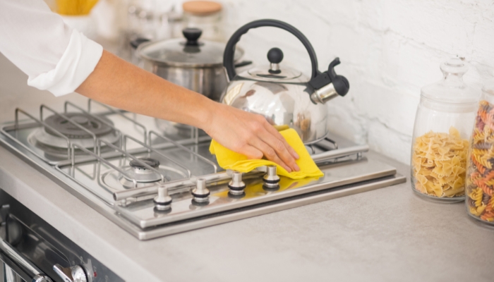 Closeup of someone cleaning their gas cooktop