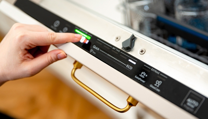 Closeup of hand choosing the eco mode on the dishwasher