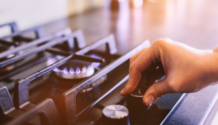 Serv_Gas-Burner-Troubleshooting_3.jpg Closeup of someone turning on a burner