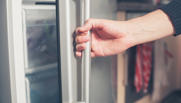 Closeup of someone opening the freezer door