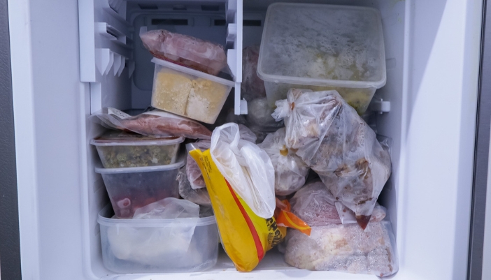 Closeup of an overloaded and disorganized freezer