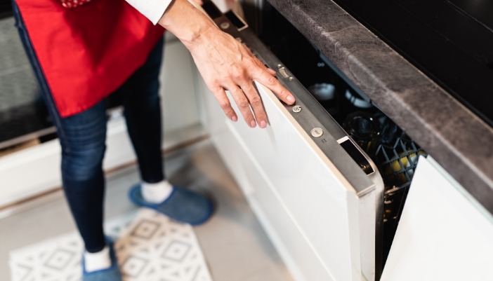 Closeup of someone selecting the right dishwasher cycle