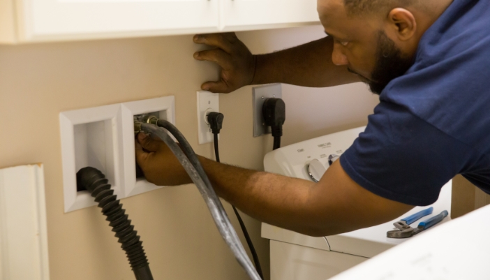 Serv_Prevent-Washing-Machine-Floods_2.jpg Closeup of someone connecting the washing machine hoses correctly