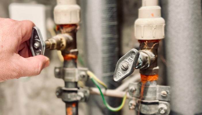Serv_Prevent-Washing-Machine-Floods_3.jpg Closeup of a hand closing turning a water shutoff valve