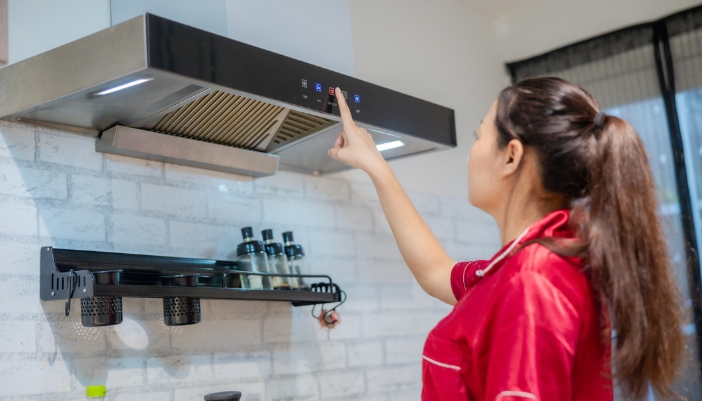Woman adjusting controls on her range hood