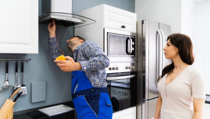 An appliance tech is inspecting the calibration on a range hood